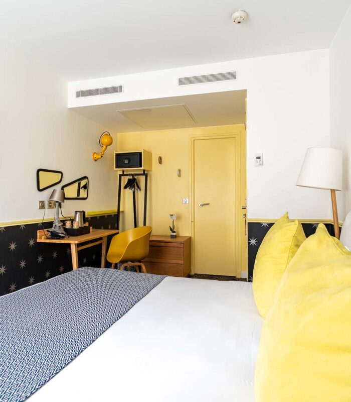 Chambre Familiale avec un lit, un bureau et une télévision à écran plat à l’hôtel Augustin