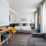 Chambre Privilège avec deux lits, un bureau et une chaise à l’Hôtel Augustin