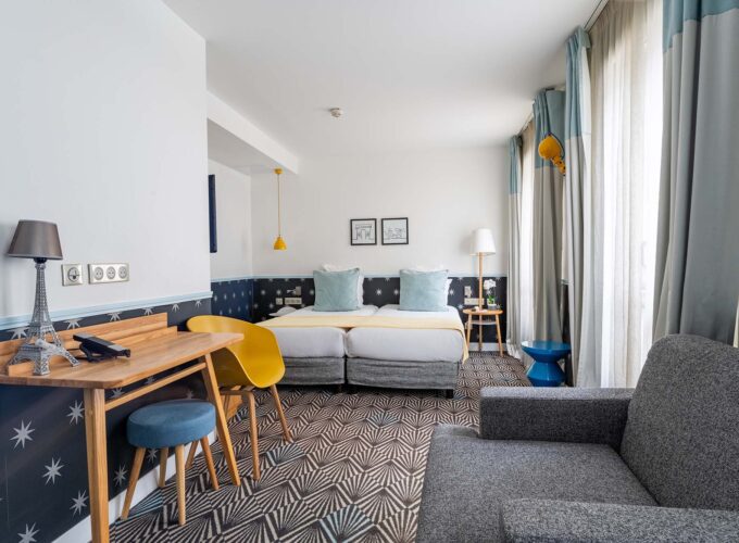 Chambre Privilège avec deux lits, un bureau et une chaise à l’Hôtel Augustin