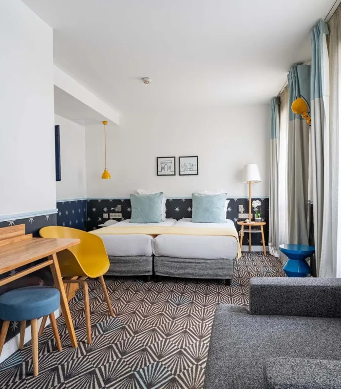 Chambre Privilège avec deux lits, un bureau et une chaise à l’Hôtel Augustin