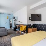 Chambre Privilège avec un lit, un bureau et une télévision à écran plat à l’Hôtel Augustin