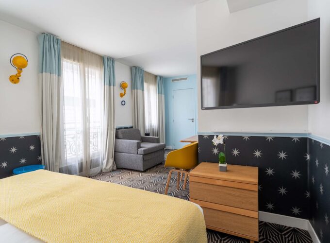Chambre Privilège avec une grande télévision à écran plat fixée au mur à l’Hôtel Augustin