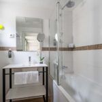 Salle de bain Privilège avec un lavabo et une baignoire à l’Hôtel Augustin