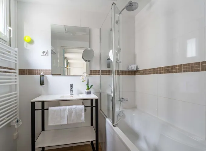 Salle de bain Privilège avec un lavabo et une baignoire à l’Hôtel Augustin