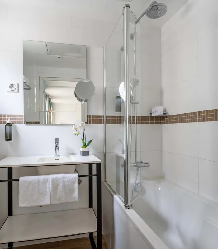Salle de bain Privilège avec un lavabo et une baignoire à l’Hôtel Augustin