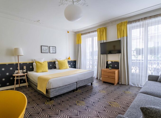 Chambre Quadruple avec un grand lit et une télévision à écran plat à l’hôtel Augustin