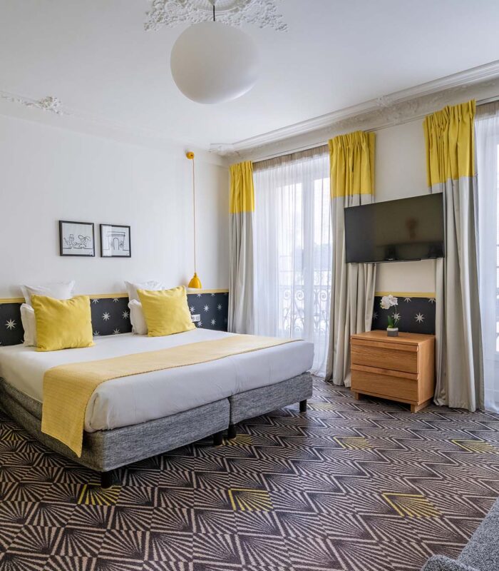 Chambre Quadruple avec un grand lit et une télévision à écran plat à l’hôtel Augustin