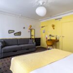 Chambre Quadruple avec un lit, un canapé et un bureau à l’hôtel Augustin