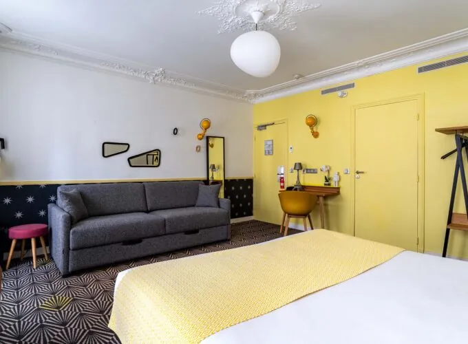 Chambre Quadruple avec un lit, un canapé et un bureau à l’hôtel Augustin