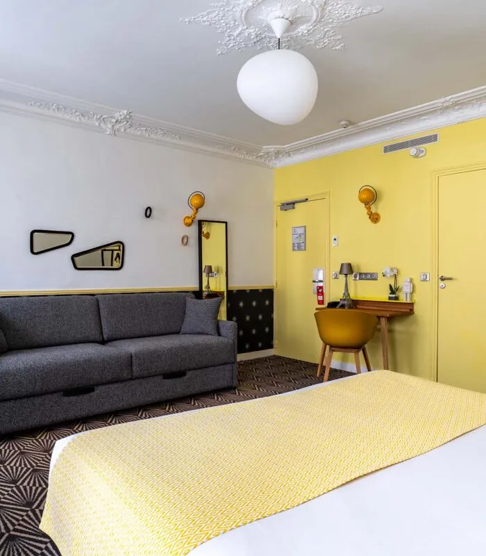 Chambre Quadruple avec un lit, un canapé et un bureau à l’hôtel Augustin