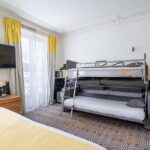 Chambre Quadruple avec un lit superposé et une télévision à écran plat à l’hôtel Augustin