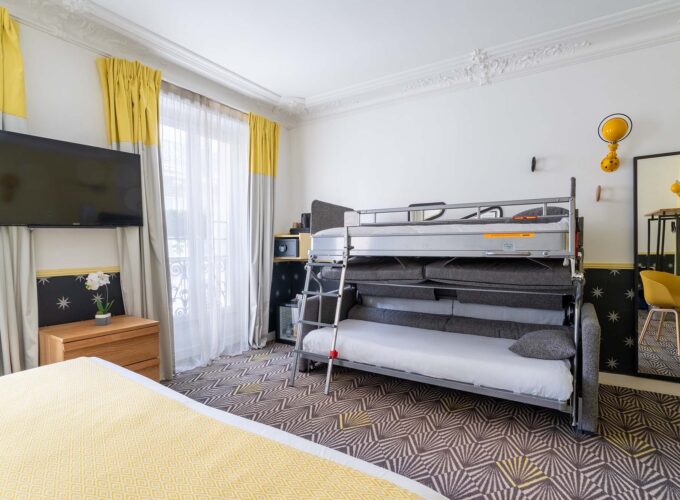 Chambre Quadruple avec un lit superposé et une télévision à écran plat à l’hôtel Augustin