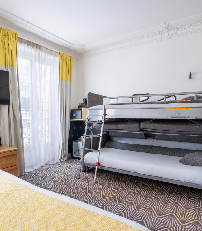 Chambre Quadruple avec un lit superposé et une télévision à écran plat à l’hôtel Augustin