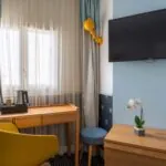 Chambre Single Cocoon, petite chambre avec un bureau et une télévision à écran plat à l’hôtel Augustin