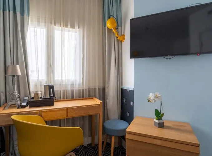 Chambre Single Cocoon, petite chambre avec un bureau et une télévision à écran plat à l’hôtel Augustin