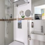 Chambre Single Cocoon, salle de bains avec un WC, un lavabo et un miroir à l’hôtel Augustin