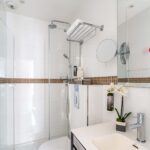 Chambre Single, salle de bains avec un lavabo, un miroir et une douche à l’hôtel Augustin