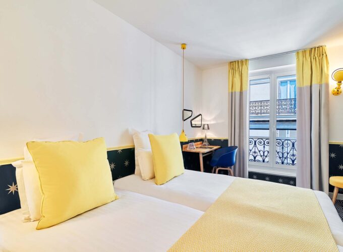 Chambre Twin avec deux lits et un bureau à l’hôtel Augustin