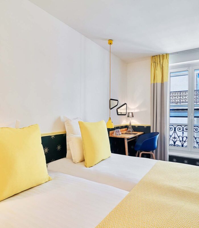Chambre Twin avec deux lits et un bureau à l’hôtel Augustin