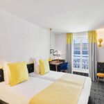 Chambre Twin avec deux lits et une télévision à l’hôtel Augustin