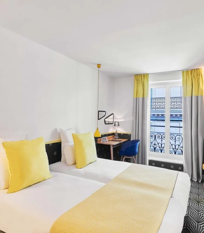 Chambre Twin avec deux lits et une télévision à l’hôtel Augustin
