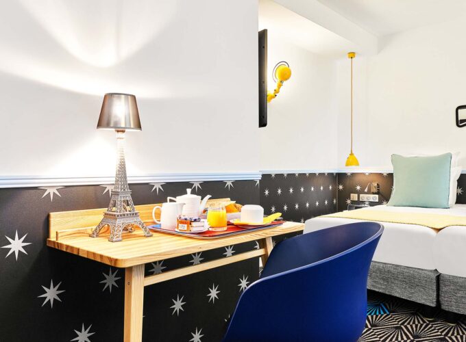 Chambre Twin avec une table portant un plateau-repas à l’hôtel Augustin