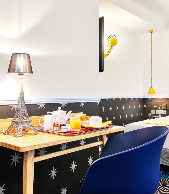 Chambre Twin avec une table portant un plateau-repas à l’hôtel Augustin