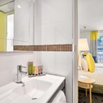 Chambre Twin, salle de bains avec un WC, un lavabo et un miroir à l’hôtel Augustin
