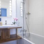 Chambre Double bathroom with a sink a mirror and a bathtub at the Hotel Bradford Elysees