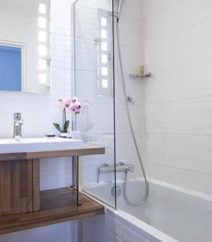 Chambre Double bathroom with a sink a mirror and a bathtub at the Hotel Bradford Elysees