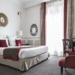 Chambre Double room with a large bed and a chair at the Hotel Bradford Elysees
