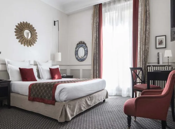 Chambre Double room with a large bed and a chair at the Hotel Bradford Elysees