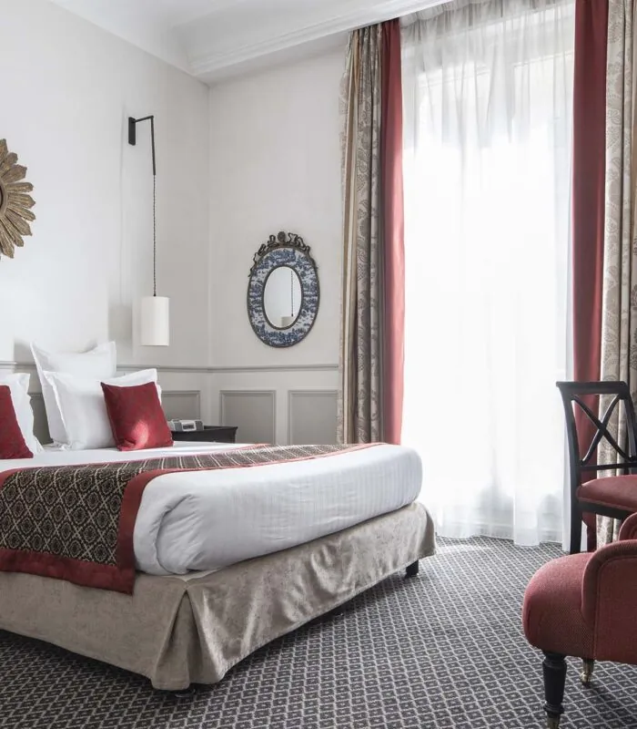 Chambre Double room with a large bed and a chair at the Hotel Bradford Elysees