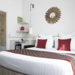 Chambre Double room with a bed and a mirror on the wall at the Hotel Bradford Elysees