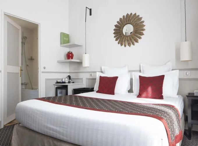 Chambre Double room with a bed and a mirror on the wall at the Hotel Bradford Elysees