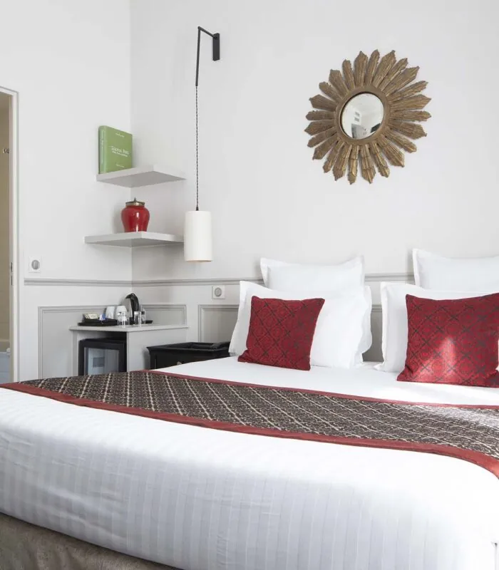 Chambre Double room with a bed and a mirror on the wall at the Hotel Bradford Elysees