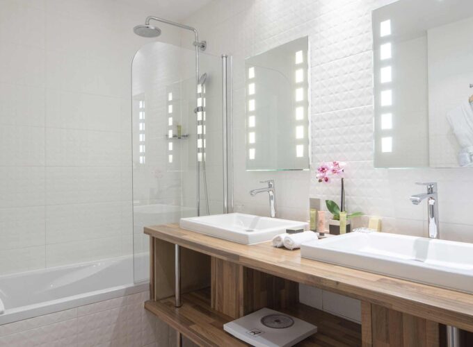 Chambre Double Privilège salle de bain avec deux lavabos et une baignoire à l’Hôtel Bradford Elysées