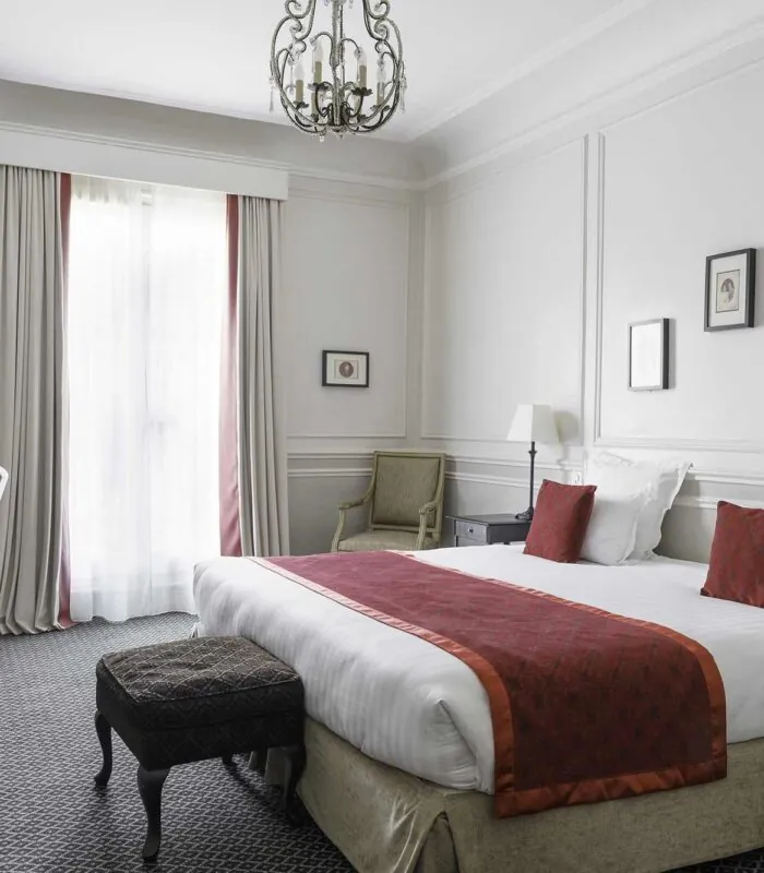 Chambre Double Privilège avec un grand lit et un bureau à l’Hôtel Bradford Elysées