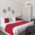 Chambre Double Privilège avec un lit et un miroir à l’Hôtel Bradford Elysées