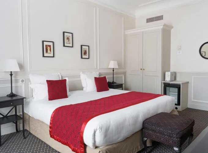 Chambre Double Privilège avec un lit et un miroir à l’Hôtel Bradford Elysées