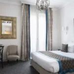 Chambre Double Supérieure avec un grand lit et un tableau accroché au mur à l’Hôtel Bradford Elysées