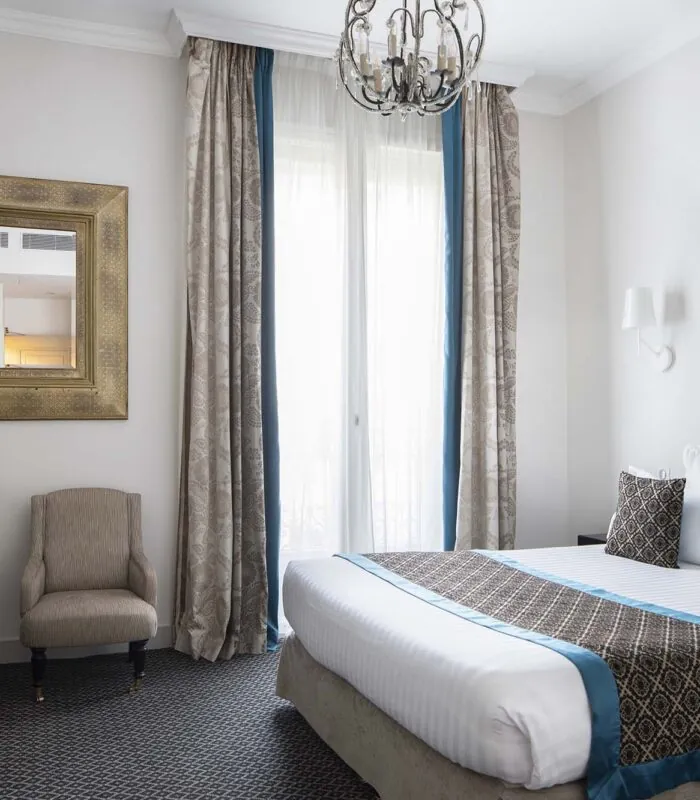 Chambre Double Supérieure avec un grand lit et un tableau accroché au mur à l’Hôtel Bradford Elysées