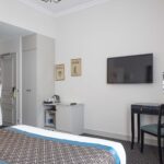 Chambre Double Supérieure avec une télévision à écran plat fixée au mur à l’Hôtel Bradford Elysées