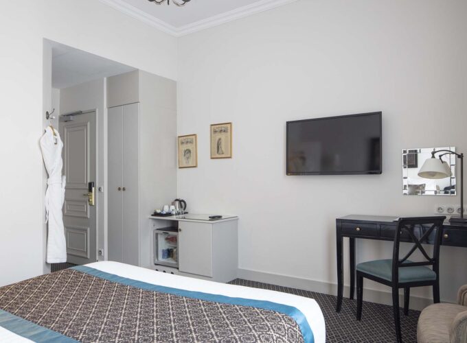 Chambre Double Supérieure avec une télévision à écran plat fixée au mur à l’Hôtel Bradford Elysées