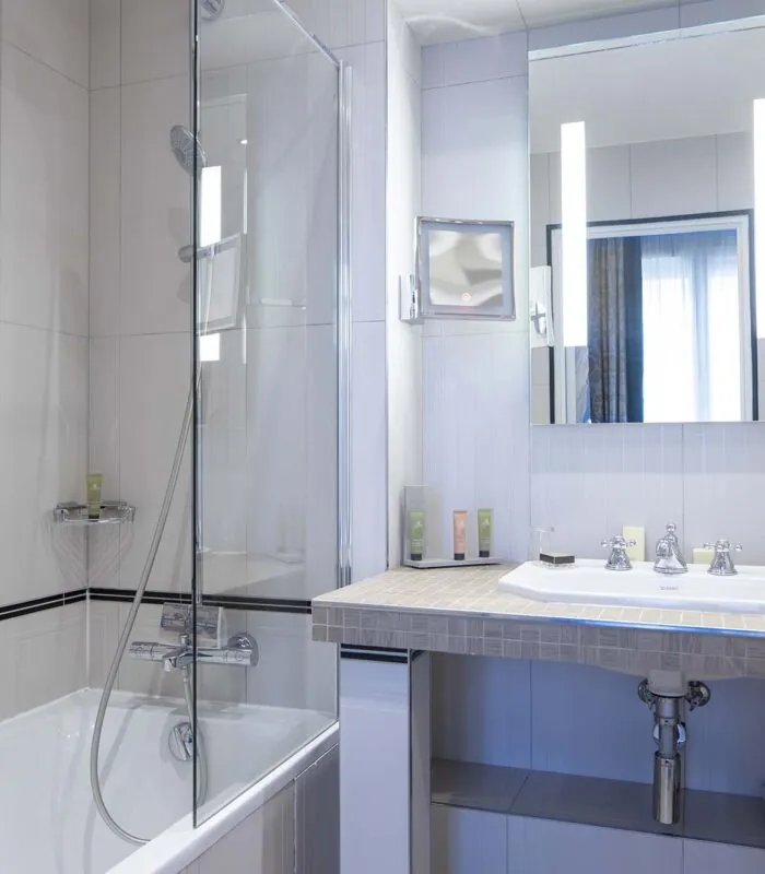 Chambre Double Supérieure salle de bain avec baignoire lavabo et miroir à l’Hôtel Bradford Elysées