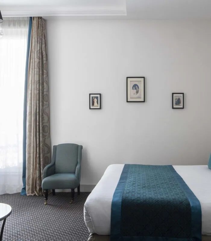 Chambre Familiale Supérieure avec un lit, une chaise et une télévision à écran plat à l’Hôtel Bradford Élysées