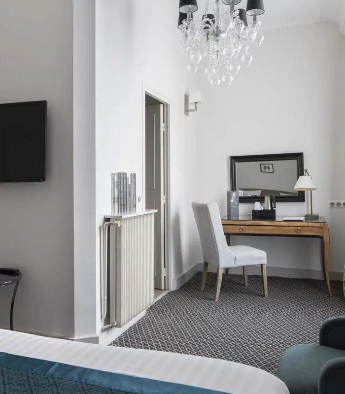 Chambre Familiale Supérieure avec un lit, une chaise et une télévision à écran plat à l’Hôtel Bradford Élysées