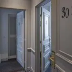 Couloir de la Chambre Familiale Supérieure avec les numéros 30 et 31 sur les portes à l’Hôtel Bradford Élysées