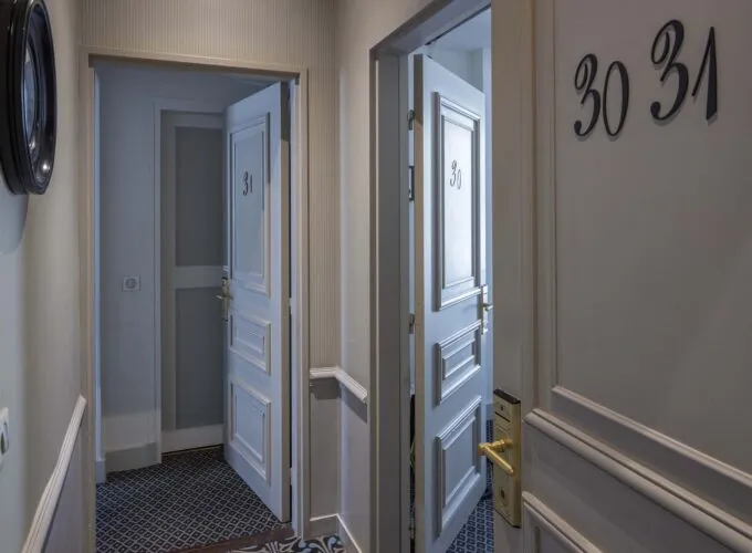Couloir de la Chambre Familiale Supérieure avec les numéros 30 et 31 sur les portes à l’Hôtel Bradford Élysées