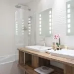 Salle de bain de la Chambre Familiale Supérieure avec deux lavabos et une baignoire à l’Hôtel Bradford Élysées